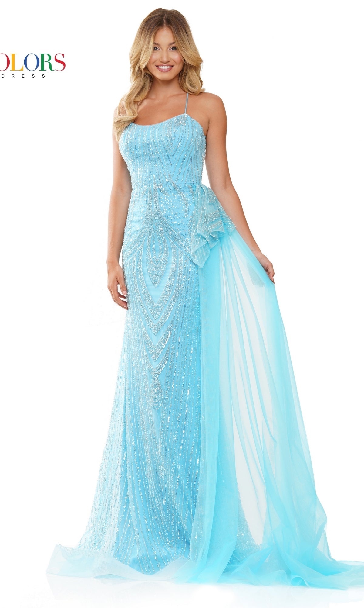 A woman in the Lace-Up Beaded Long Prom Dress 3121, featuring light blue fabric, floor-length design, and a sheer draped overlay, stands smiling against a white background.